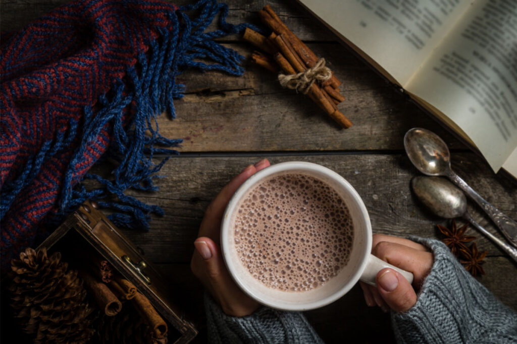 Image showing a close view of the hands holding a mug of hot chocolate.