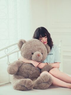 sad-woman-cuddling-with-giant-teddy-bear
