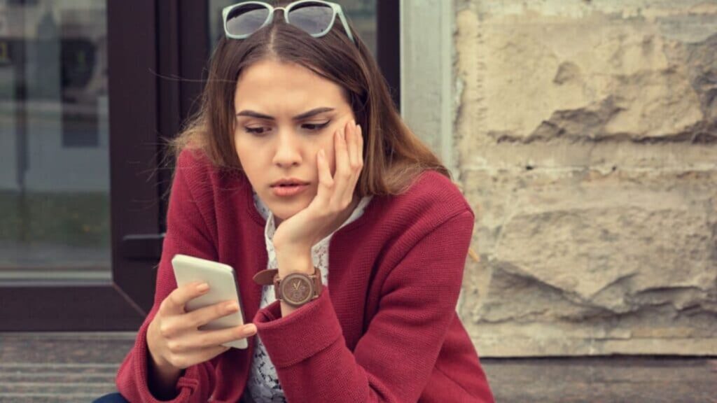 woman on her phone concerned confused