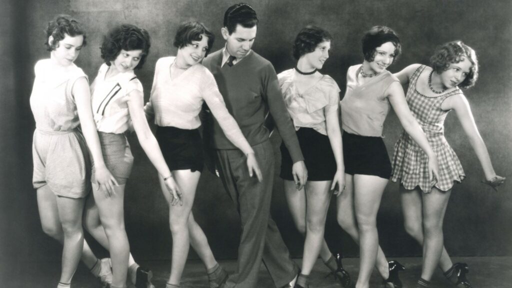 A man and group of girls dancing in 60s