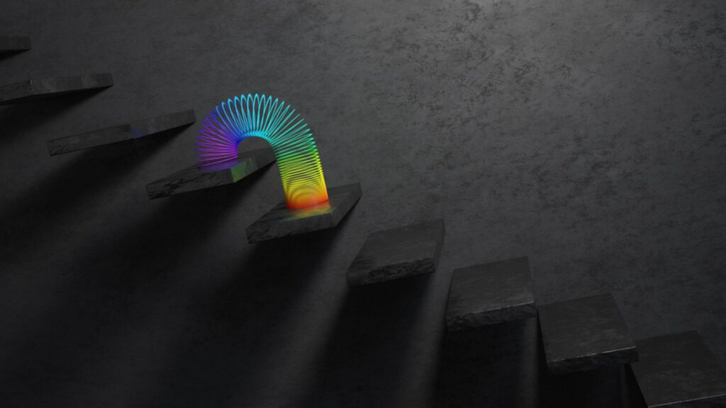 A rainbow themed slinky toy walking downstairs
