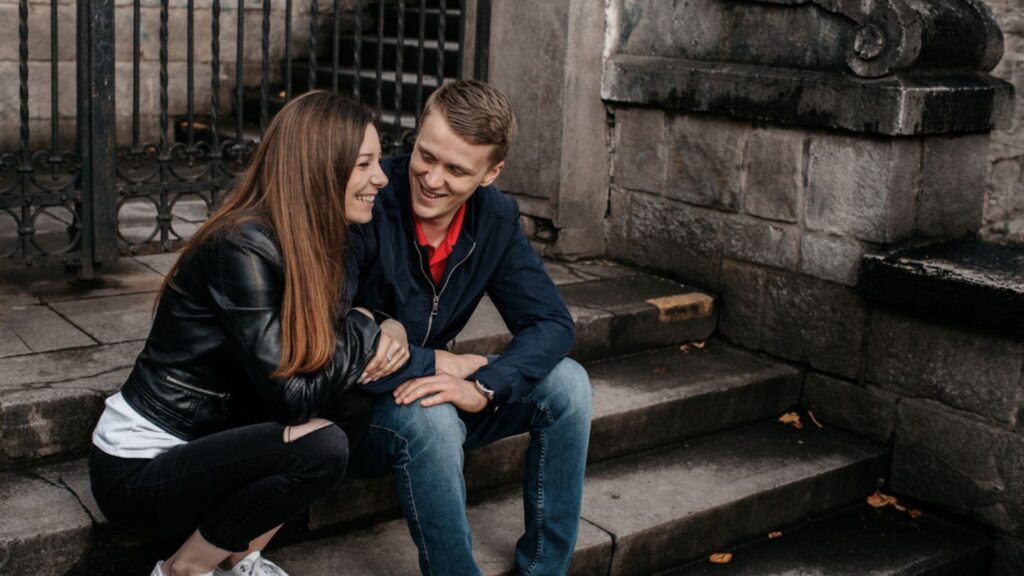 A student couple in love flirting outside stairs