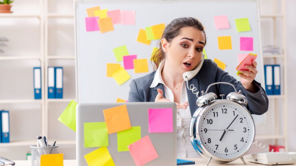 Busy Young female employee in conflicting priorities concept