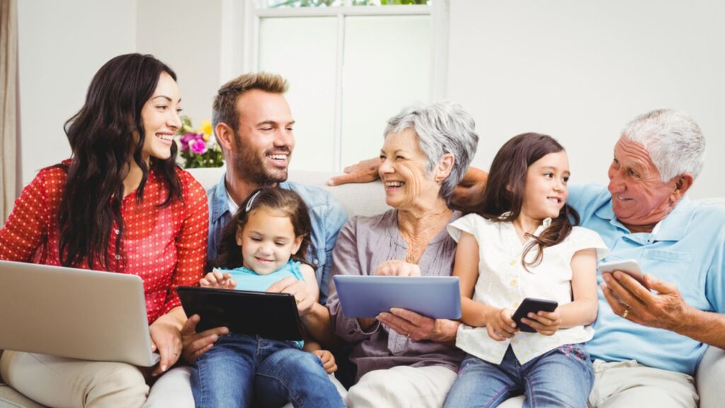 Family smiling while holding technologies