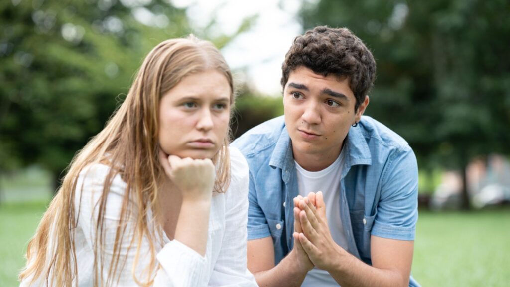 Hispanic teenager boy asking for forgiveness at girlfriend