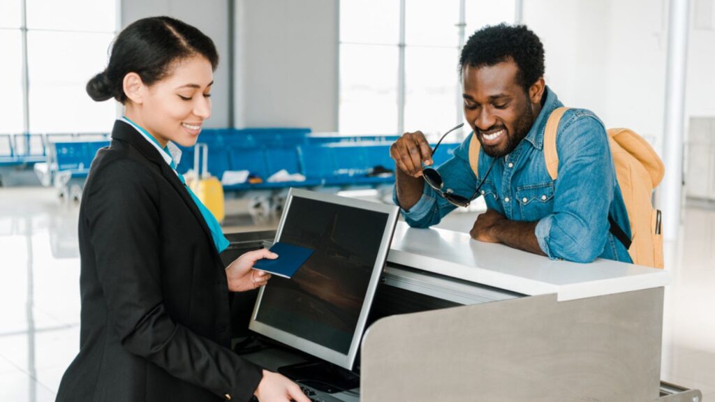 Smiling african american airport worker checking air ticket and passport
