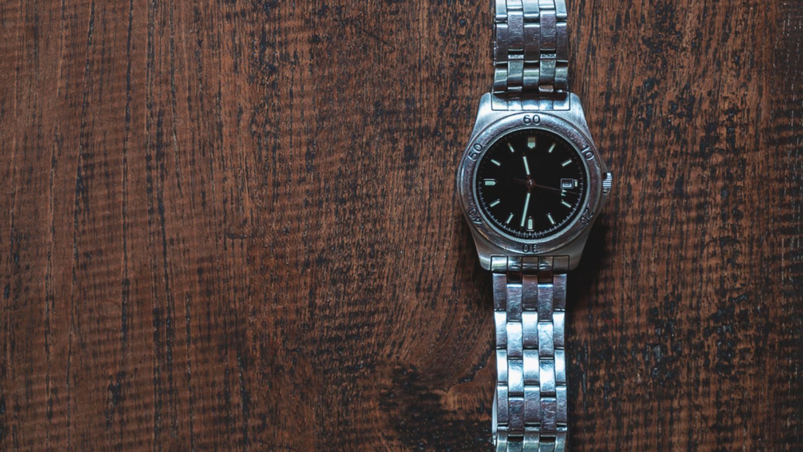 Stainless steel watch on wooden background