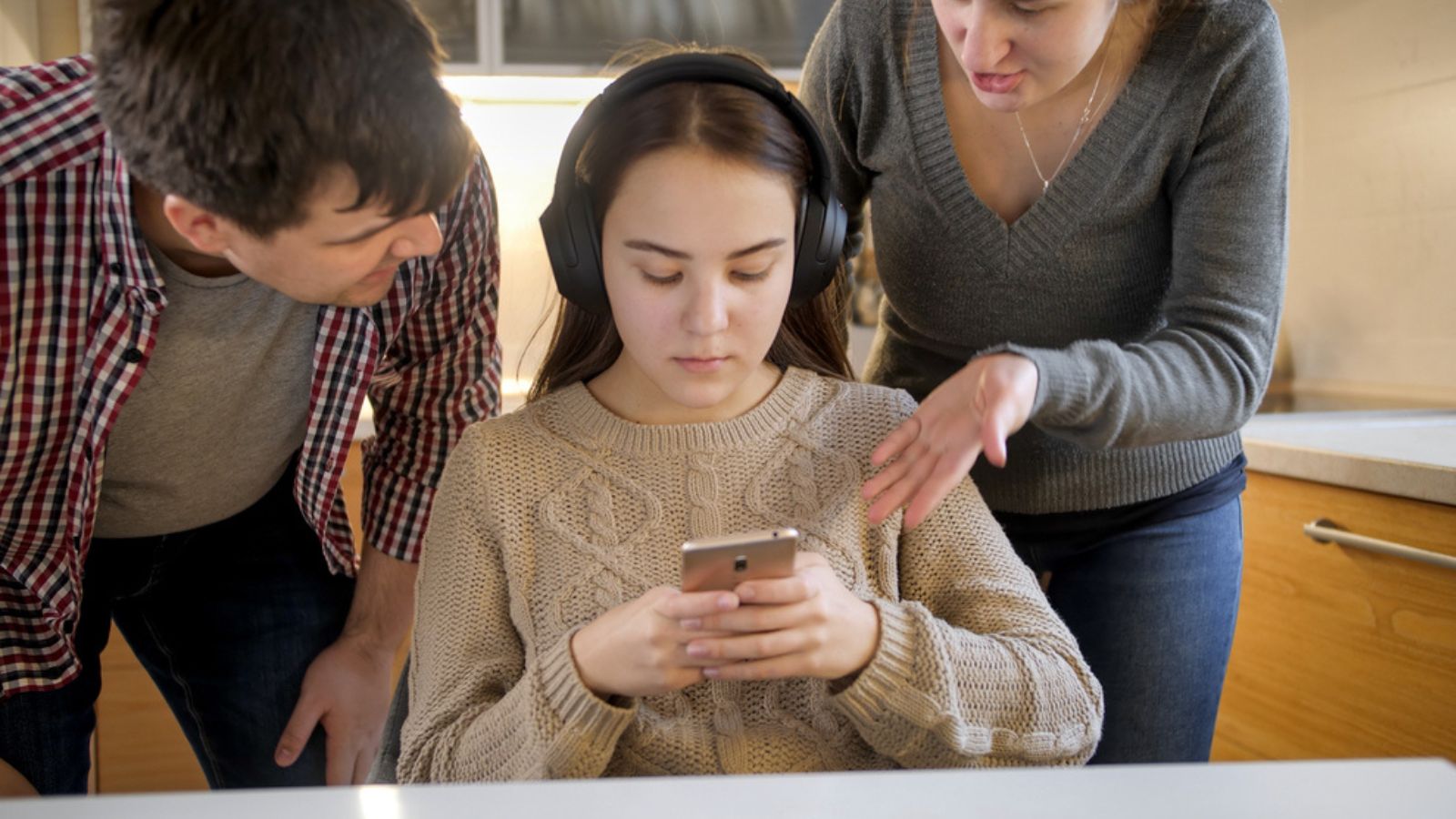 Teenage girl listening music and using smartphone while parent shouting at her but she ignoring her parents