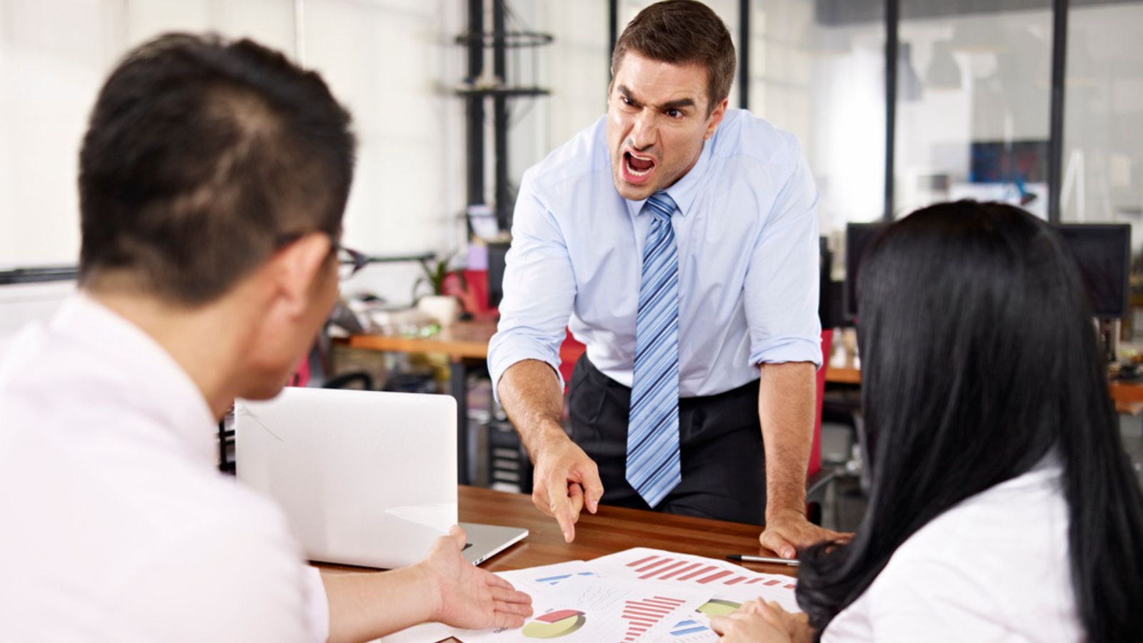 angry boss yelling at his employees in the office