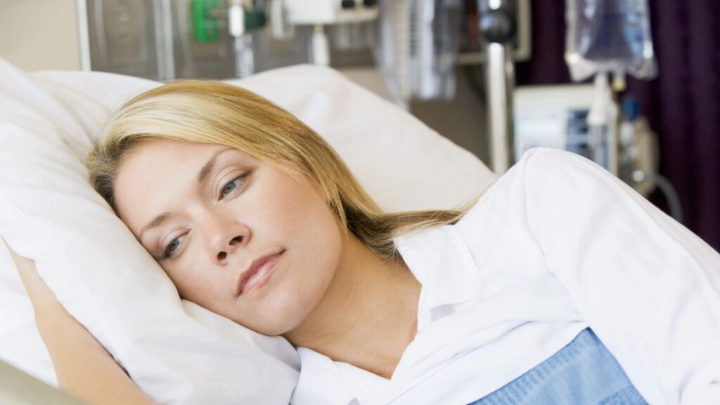 Woman Lying Down In Hospital Bed