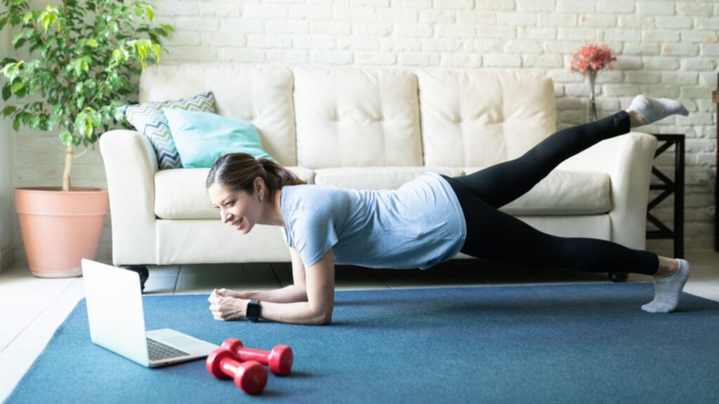 Woman in Plank Position Watching Laptop Screen