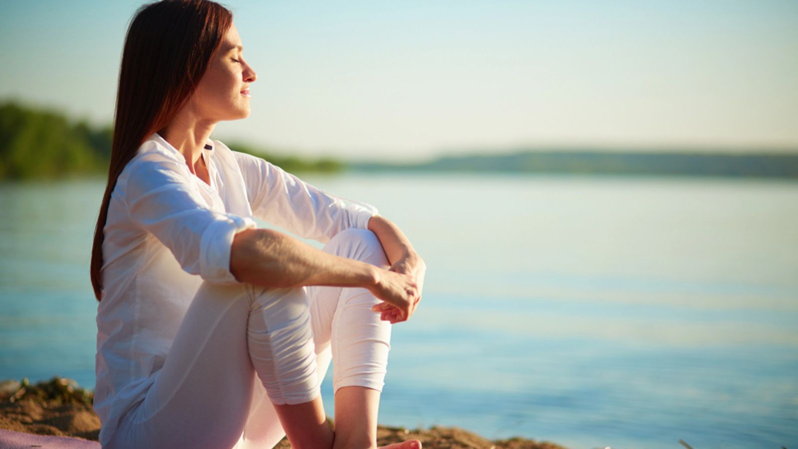 Woman sitting on sandy beach