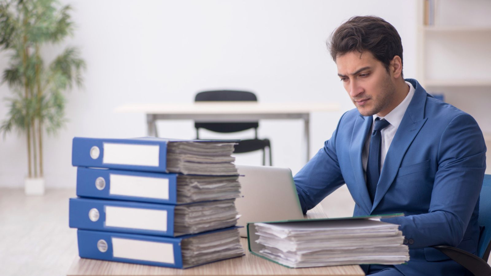 Young businessman employee and too much work at workplace