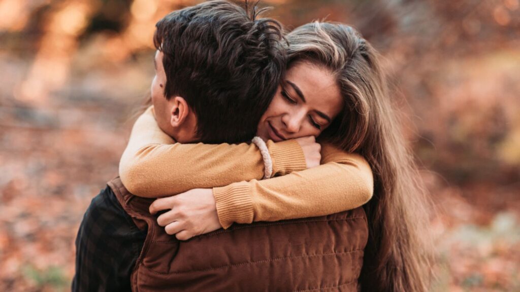 Young, romantic couple in tight embrace in the woods