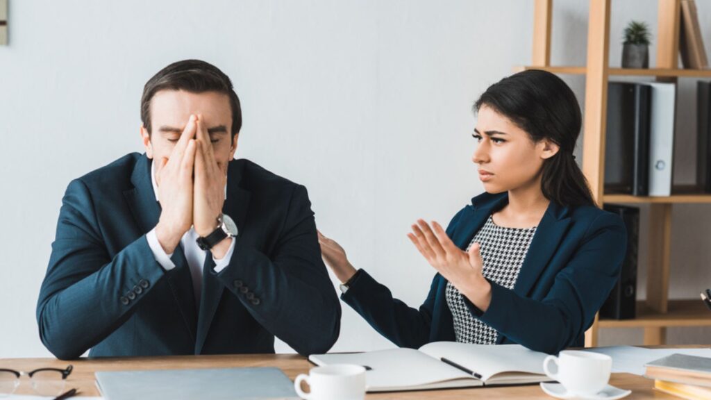 A man and Woman In Office, Woman is Arguing on something, Man is Sad