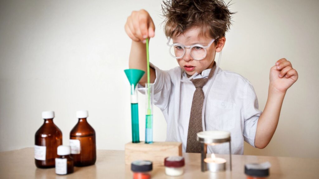 Crazy scientist. Young boy performing experiments