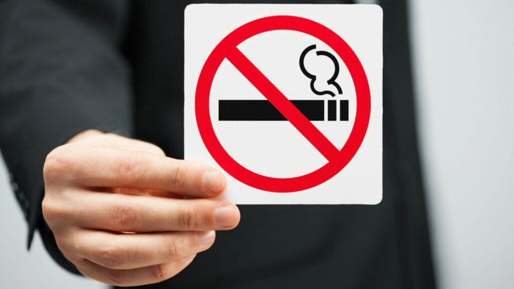 Man in suit holding no smoking sign