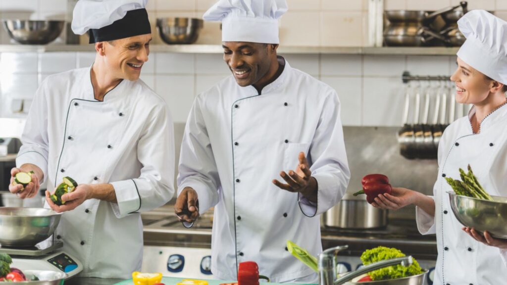 Smiling multicultural chefs talking at restaurant kitchen