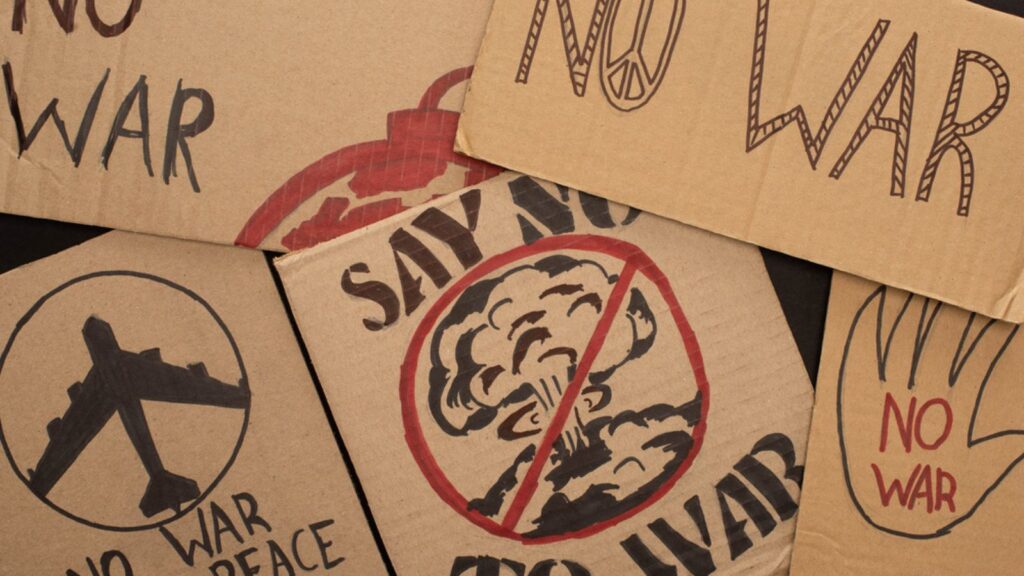 Top view of cardboard placards with no war lettering and drawings on black background