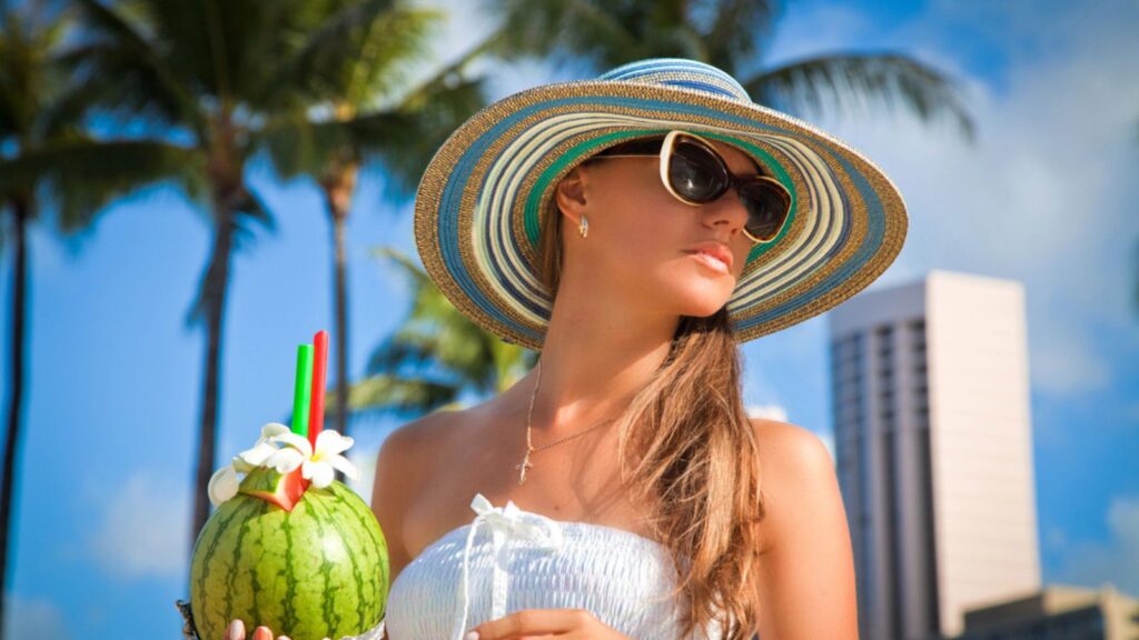 rich woman on vacation tropical drink relaxing sunglasses