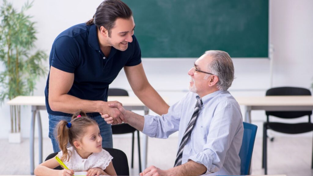 Young parent, old male teacher and little girl in the classroom