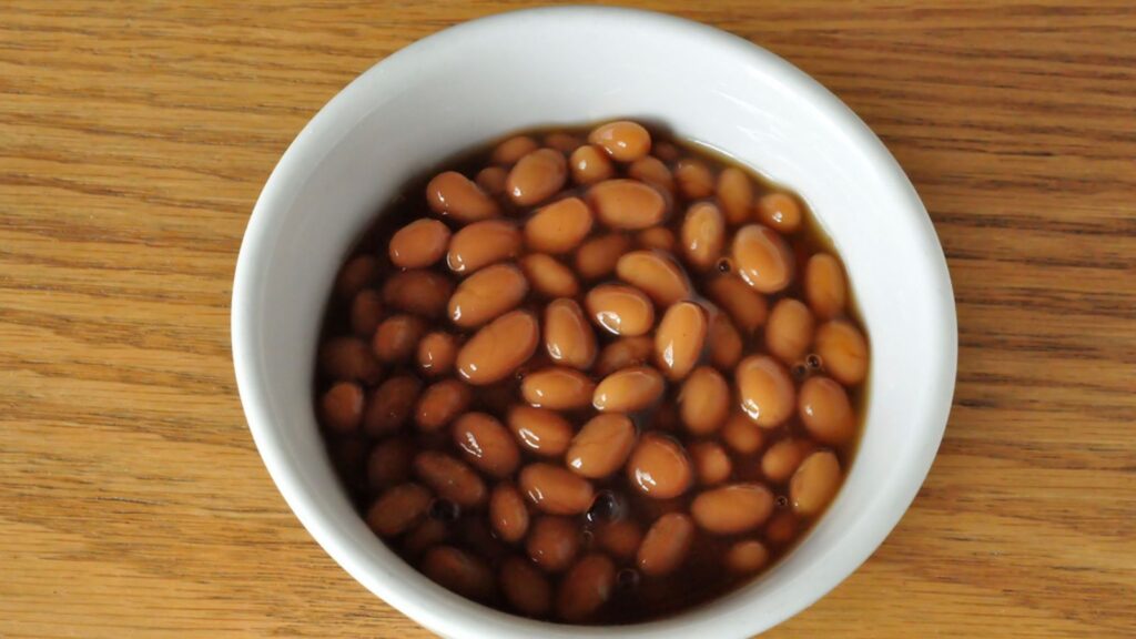 Bowl of Baked Beans on wooden table