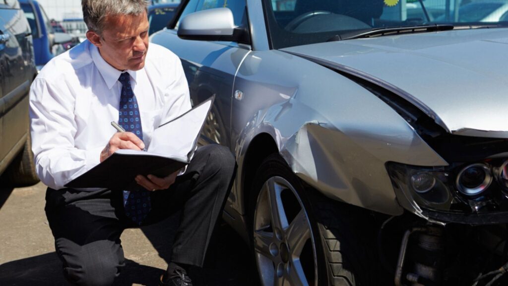 Claims Adjuster is review the accidental car for insurance