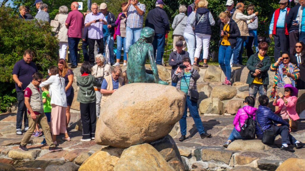 _Crowds of tourists surround the Hans Christian Andersen Little Mermaid statue The Little Mermaid, Copenhagen
