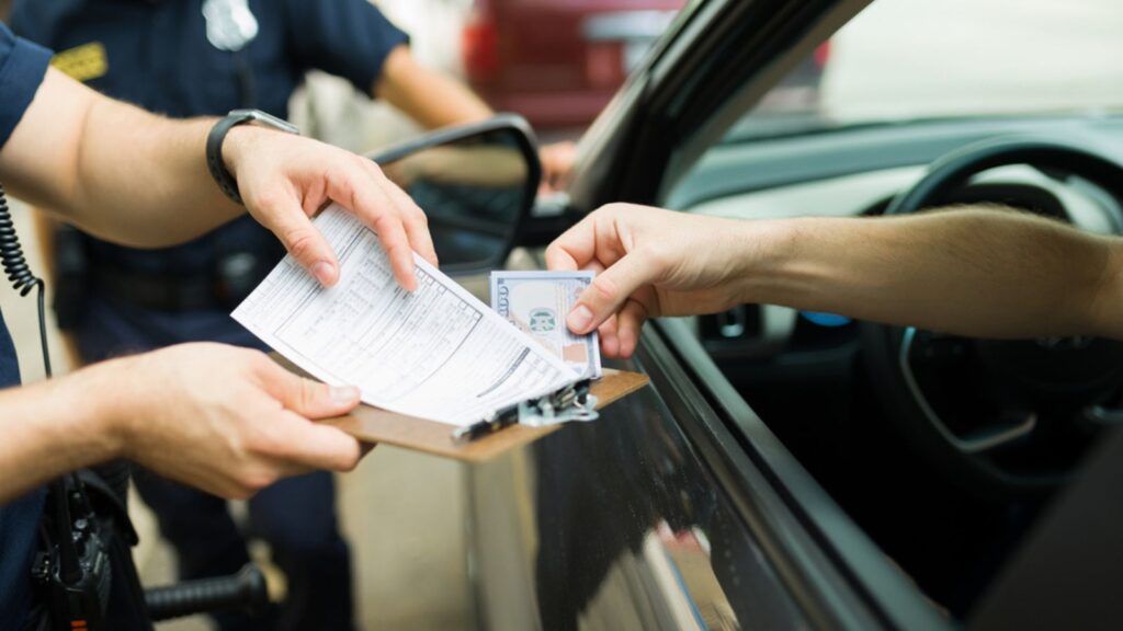 Driver giving bribe money to police cops for receiving a traffic fine or speeding ticket