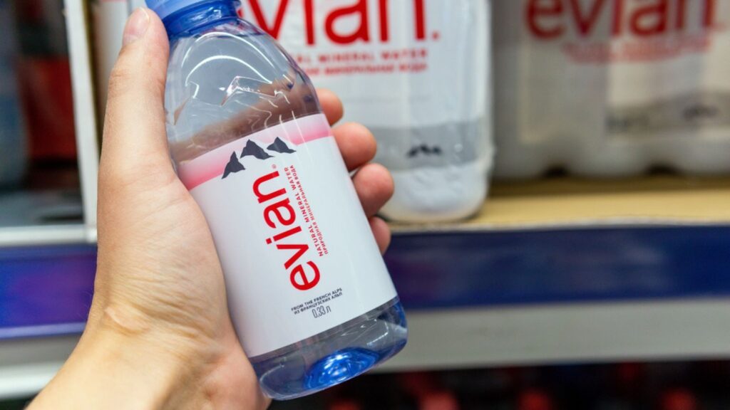 Evian brand drinking water, are placed on shelves display in the grocery store
