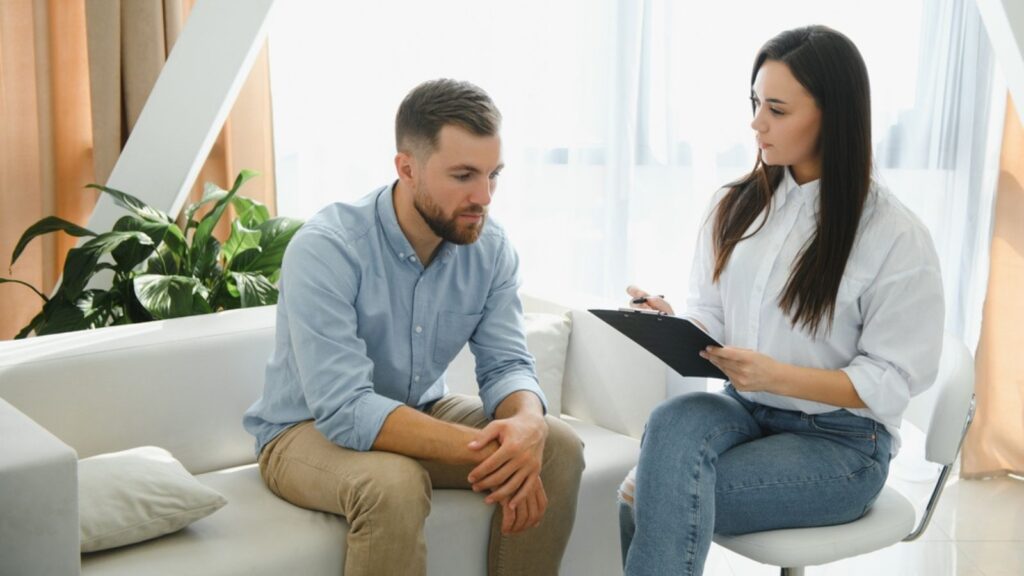 Female psychologist making note while patient talking.