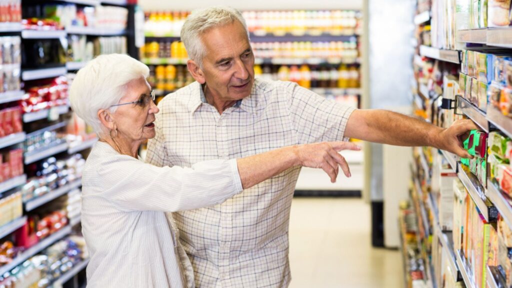 Happy senior couple choosing food at supermarket
