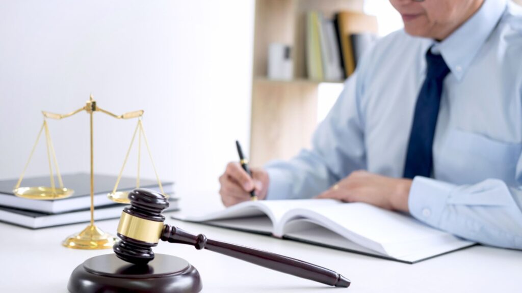 Judge gavel with scales of justice, male lawyers working having at law firm in office. Concepts of law.