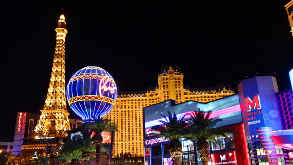 The Paris Las Vegas is a hotel and casino in Nevada. Seen on the left are the venues replicas of the Eiffel Tower and the Montgolfier Balloon adorned in bright lights.