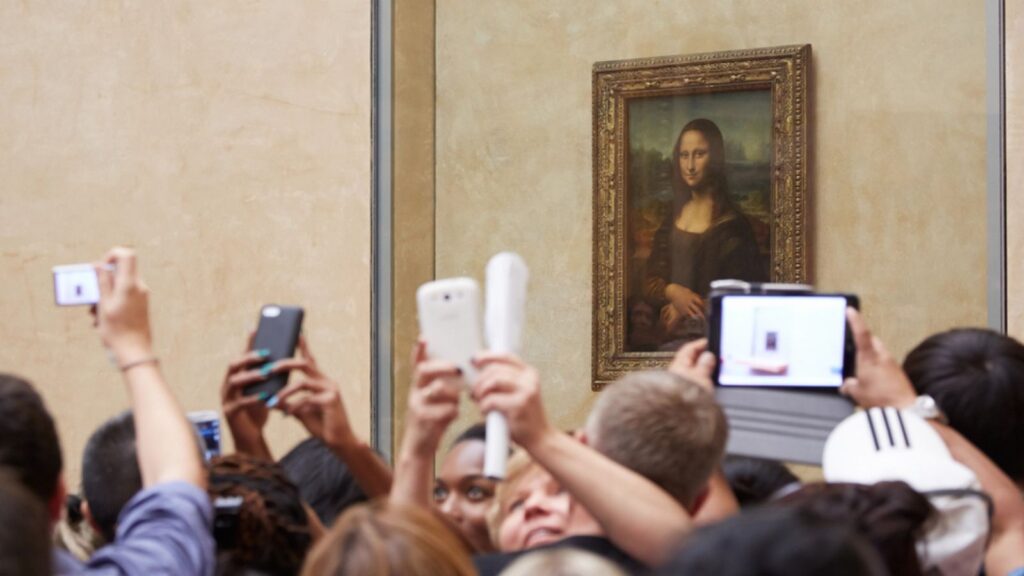 Tourists take photos and selfies of Leonardo DaVinci's Mona Lisa at the Louvre Museum