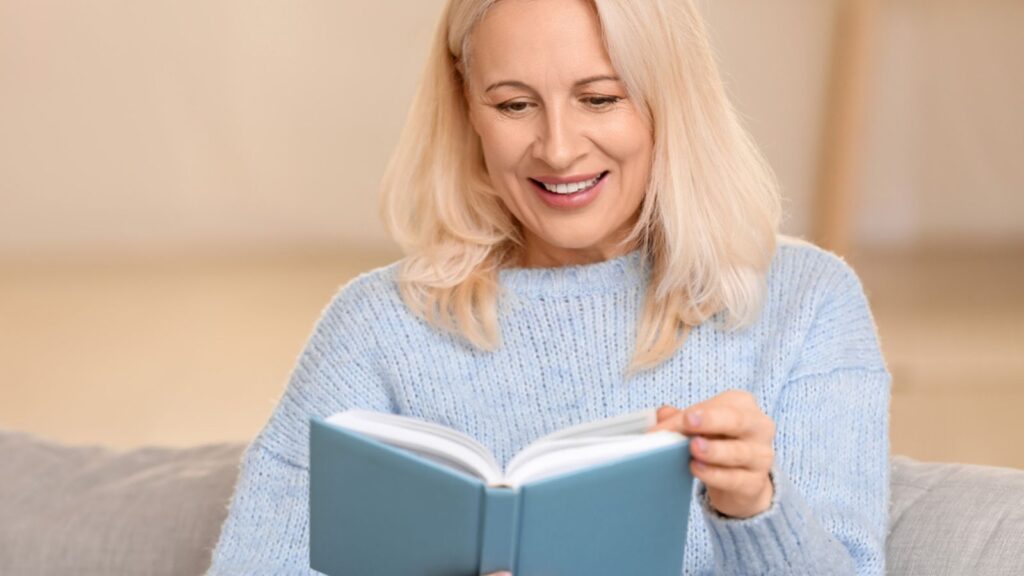 Beautiful mature woman reading book at home