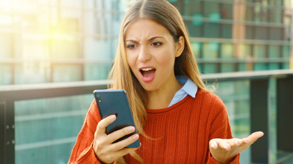 Disappointed angry woman receiving wrong content online on mobile phone