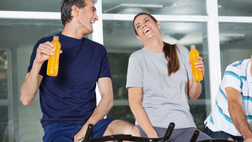 Happy Man And Woman Holding Juice Bottles and smiling