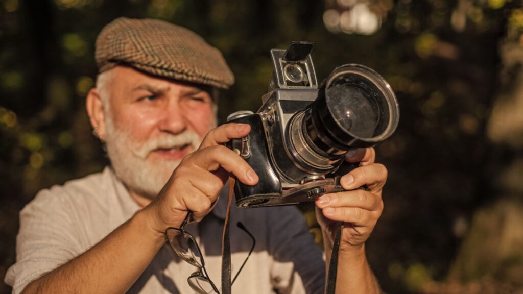 He likes birdwatching. Make perfect frame. Old photographer filming