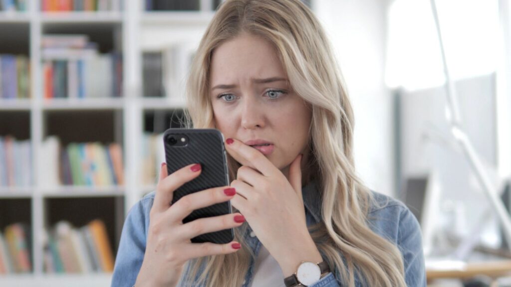 Sad Woman Reacting to Loss on Smartphone