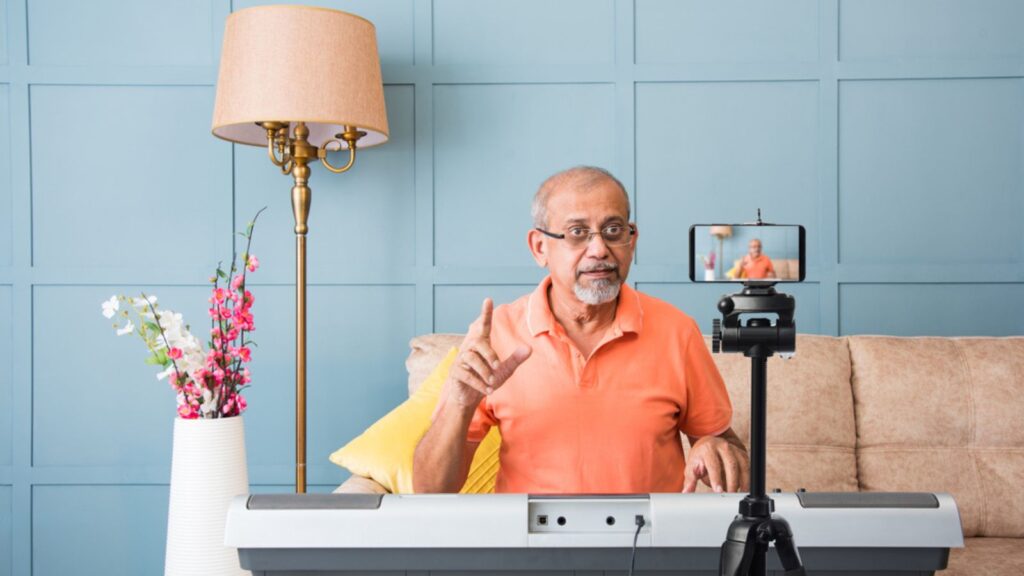 Senior Asian Indian musician performing while taking online music class