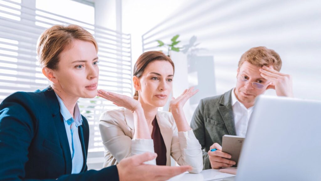 Serious problematic sad man and women looking at the laptop screen in the office