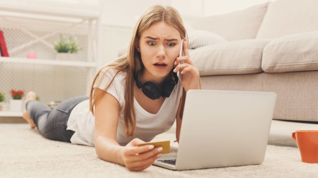 Shocked young girl with laptop indoors
