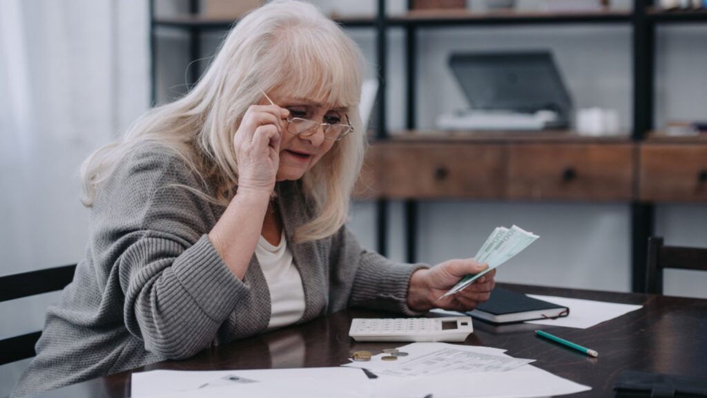 old woman doing her taxes calculator money
