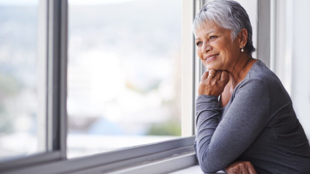 happy old woman thinking looking out the window