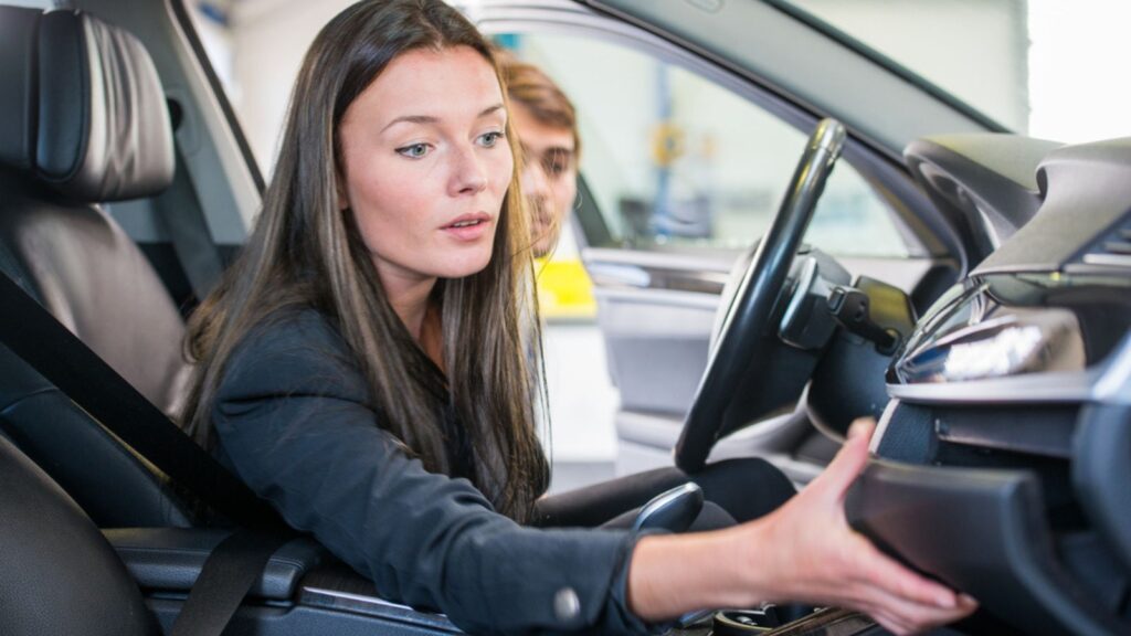 woman in a car checking her glove box
