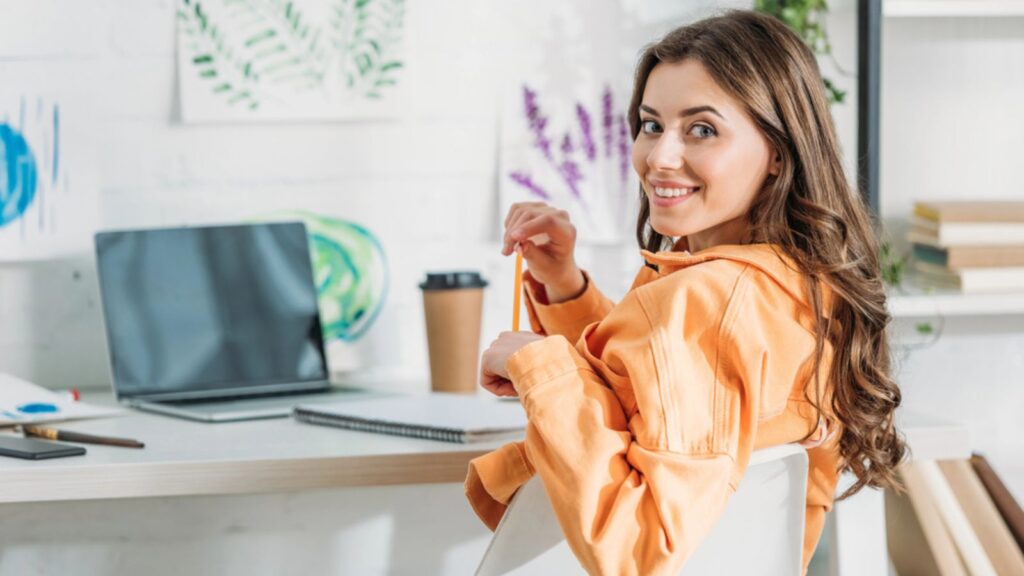 woman working at her desk computer happy coffee flowers