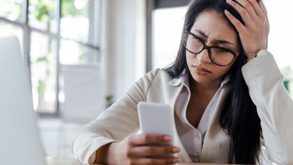 stressed frustrated woman with a phone and computer glasses