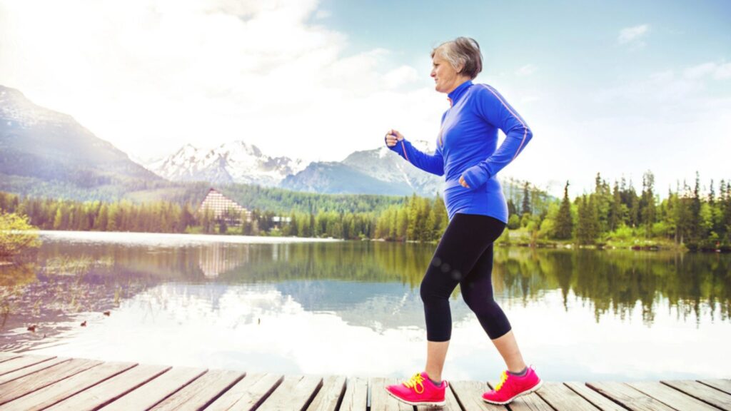 old woman running in nature athlete jog water lake