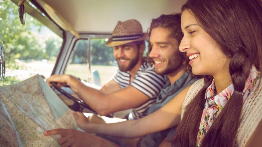 friends road trip looking at a map driving